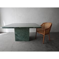 a green marble table and chair in an empty room