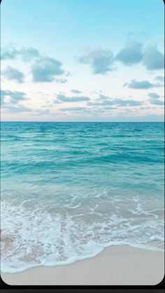 an ocean view with waves coming in to the shore and blue sky above it, framed by a black frame