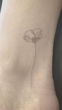 a small flower on the ankle is shown in black and grey ink, with a thin line