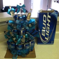 an arrangement of beer cans is displayed in front of a soda box and blue ribbon