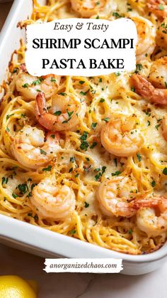 shrimp scampi pasta bake in a white casserole dish with lemons and parsley