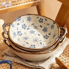 three blue and white bowls sitting on top of a table next to a pair of scissors