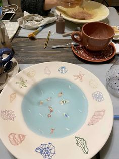 there is a plate with designs on it sitting on the table next to other plates