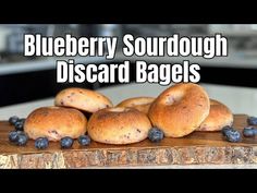 blueberry sourdough bagels on a cutting board with the words blueberry sourdough discard bags