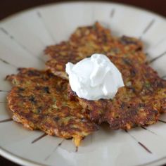 some food is sitting on a white plate with a dollop of sour cream on top