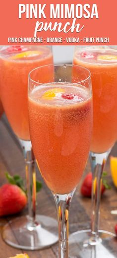 three wine glasses filled with liquid and garnished with strawberries on the table