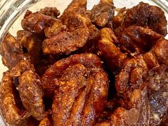 a glass bowl filled with cooked meat on top of a table