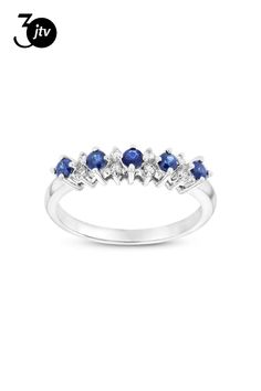 a white gold ring with three blue sapphire stones on the side and two diamonds in the middle