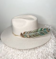 Add some sparkle to any cowgirl hat with this turquoise and gold hand painted turkey feather Glitter & Rhinestone strand on spine of feather make it super sparkly and perfect for any holiday, party, or event!!  This listing is for one feather decoration, hat not included, but you can purchase this feather and one of our custom decorated hats to be the room stunner! Each feather is one of a kind Check out all of our NEW hat decorations in our shop! Bohemian Mini Hat With Feathers, Adjustable Feather Trim Hat Band For Festival, Adjustable Hat Bands With Feather Trim For Festivals, Adjustable Festival Hat Band With Feather Trim, Adjustable Green Bohemian Felt Hat, Adjustable Felt Hat With Feathers For Festivals, Bohemian Adjustable Felt Hat With Feathers, Bohemian Hat Band With Feather Trim And Adjustable Fit, Adjustable Fedora With Feathers For Festivals