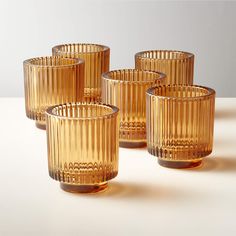 four yellow glass cups sitting on top of a table