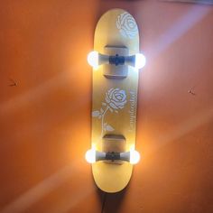 a skateboard mounted to the side of a wall with two lights on it's sides