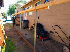 a backyard area with a lawn mower and other items on the ground near a house