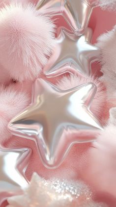 pink and silver star decorations with pom - poms in the foreground, on a soft pink background