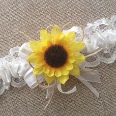 a yellow sunflower is sitting on top of a white garter with lace around it