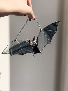 a bat hanging from a chain in someone's hand