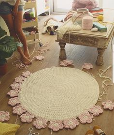 a woman standing next to a rug on top of a wooden floor