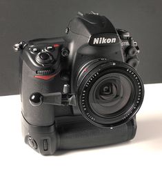 a black camera sitting on top of a white table