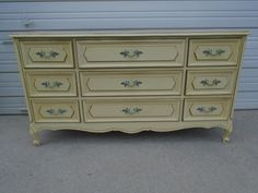 an old dresser is painted yellow with green accents