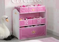 a white duck sitting in front of a pink toy shelf with princess items on it