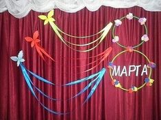 the curtain is red and white with some colorful streamers hanging from it's sides