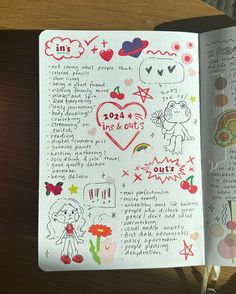 an open notebook with doodles and drawings on the pages, sitting on a table