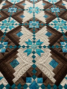 a blue and brown quilt on a bed