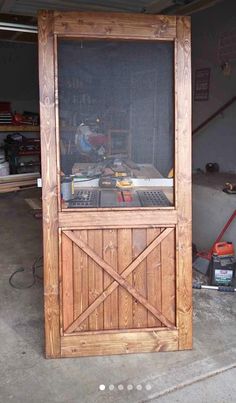 an old wooden door with a screen on it's side and tools in the background