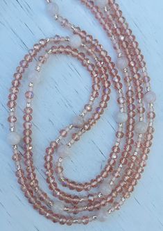 a long beaded necklace with pink and white beads