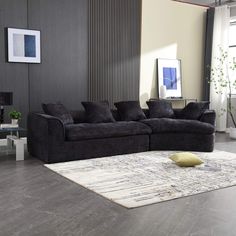 a black couch sitting on top of a rug in a living room next to a window