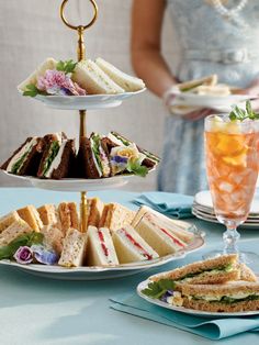 three tiered plates with sandwiches and drinks on them