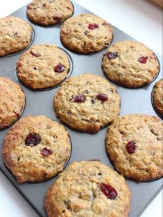 muffins with cranberries are sitting on a baking tray