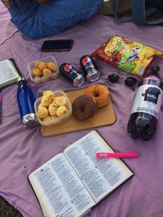 an open book sitting on top of a table next to donuts and other items