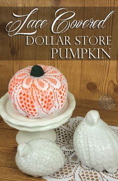 a white plate topped with a pumpkin on top of a wooden table covered in doily