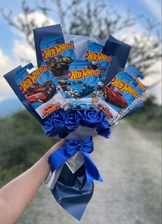 a person holding up a bunch of hot wheels flowers