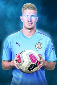 a man holding a soccer ball in front of a blue background with the words manchester city on it