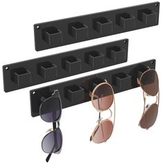 three pairs of sunglasses are hanging on the wall next to an eyeglass holder that holds four pairs of sunglasses