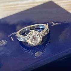 an engagement ring sits on top of a blue box