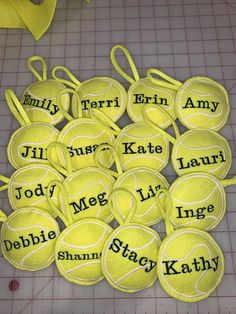 tennis balls with names on them sitting on a cutting board next to scissors and paper