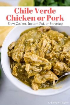 a white bowl filled with chicken and green salsa next to cilantro, tortilla chips