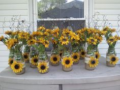 sunflowers are arranged in mason jars on a table with the word pinterest