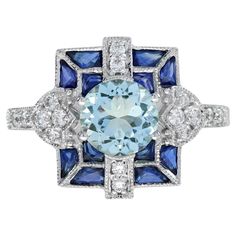 This is a stunning blue gemstones ring and one that would make a unique engagement ring as well. Made in white gold in style and design reminiscent of Art Deco era, the design of this ring has a wonderful geometric design. The ring is set with a round cut aquamarine for its center with diamond and blue sapphires accent. Ring Information Style: Art-deco Metal: 18K White Gold Total weight: 4.50 g. (approx. total weight) Ring size: US 3 – 8 available Center Gemstones Type: Aquamarine Shape: Round Size: 6.5 mm. Number: 1 Weight: 1.20 Carat (approx. total weight) Accent Gemstones Type: Blue Sapphire Shape: French Cut Size: 4 x 3, 2.5 mm. Number: 12 Weight: 2.20 Carat (approx. total weight) Accent Gemstones Type: Diamond Shape: Round Average Color: H Average Clarity: SI Size: 1.3 - 1.7 mm. Numbe Blue Gemstone Rings, Number 12, Engagement Sets, French Cut, Unique Engagement Ring, Art Deco Engagement, Gold Art Deco, Art Deco Stil, Estilo Art Deco