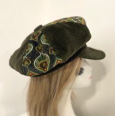 A handmade baker hat featuring the Stan&Gwyn green feather print.  The cap consists of 8 panels which are made from a mixture of faux suede, a Stan&Gwyn design printed luxurious velvet and a jumbo corduroy. It has a peek, band and a large covered button on the top. It is lined in a sturdy and breathable plain cotton. I offer these in 3 sizes - Small - 22" Medium - 23" Large - 24" Or send me your head measurement for a made to fit hat. Please note that the placement of the print will vary from ea Retro Green Cotton Hat, Green Retro Cotton Hat, Vintage Green Adjustable Hat, Vintage Green Hat, Adjustable Retro Beret Cap, Green Retro Hat With Short Brim, Retro Green Hat With Short Brim, Green Short Brim Hat, One Size, Green Short Brim Hat One Size