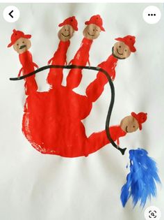 a paper plate with a drawing of three people in red hats and holding a blue feather