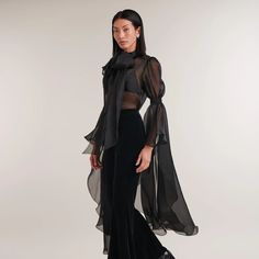 Introducing Paris, a captivating black sheer silk organza shirt exuding elegance and allure. Featuring a classic collar, covered button placket, and a removable tie for versatile styling. The gathered sleeves and cascading ruffle add drama and sophistication. Embrace the sheer beauty of Paris, a must-have for a fashion-forward wardrobe. Body: 100% Silk Please refer to care instructions on garment Luxury Long Sleeve Sheer Blouse, Luxury Sheer Long Sleeve Blouse, Luxury Sheer Blouse With Long Sleeves, Formal Long Sleeve Sheer Blouse, Formal Sheer Long Sleeve Blouse, Luxury Sheer Sleeves Party Blouse, Luxury Sheer Tops For Party, Chic Sheer Blouse For Formal Occasions, Evening Long Sleeve Organza Top