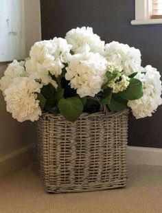 a wicker basket with white flowers in it