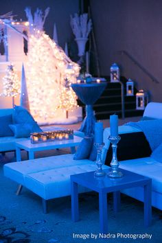 a living room filled with lots of furniture covered in blue lights and snow flakes