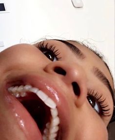 a close up of a child's mouth with long, thick eyelashes and an open tooth