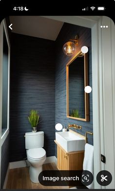 a bathroom with a toilet, sink and mirror in it's centerpieces