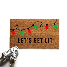 a door mat that says let's get lit with christmas lights and tennis shoes