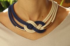 a woman wearing a blue and white necklace with two rings on it's neck